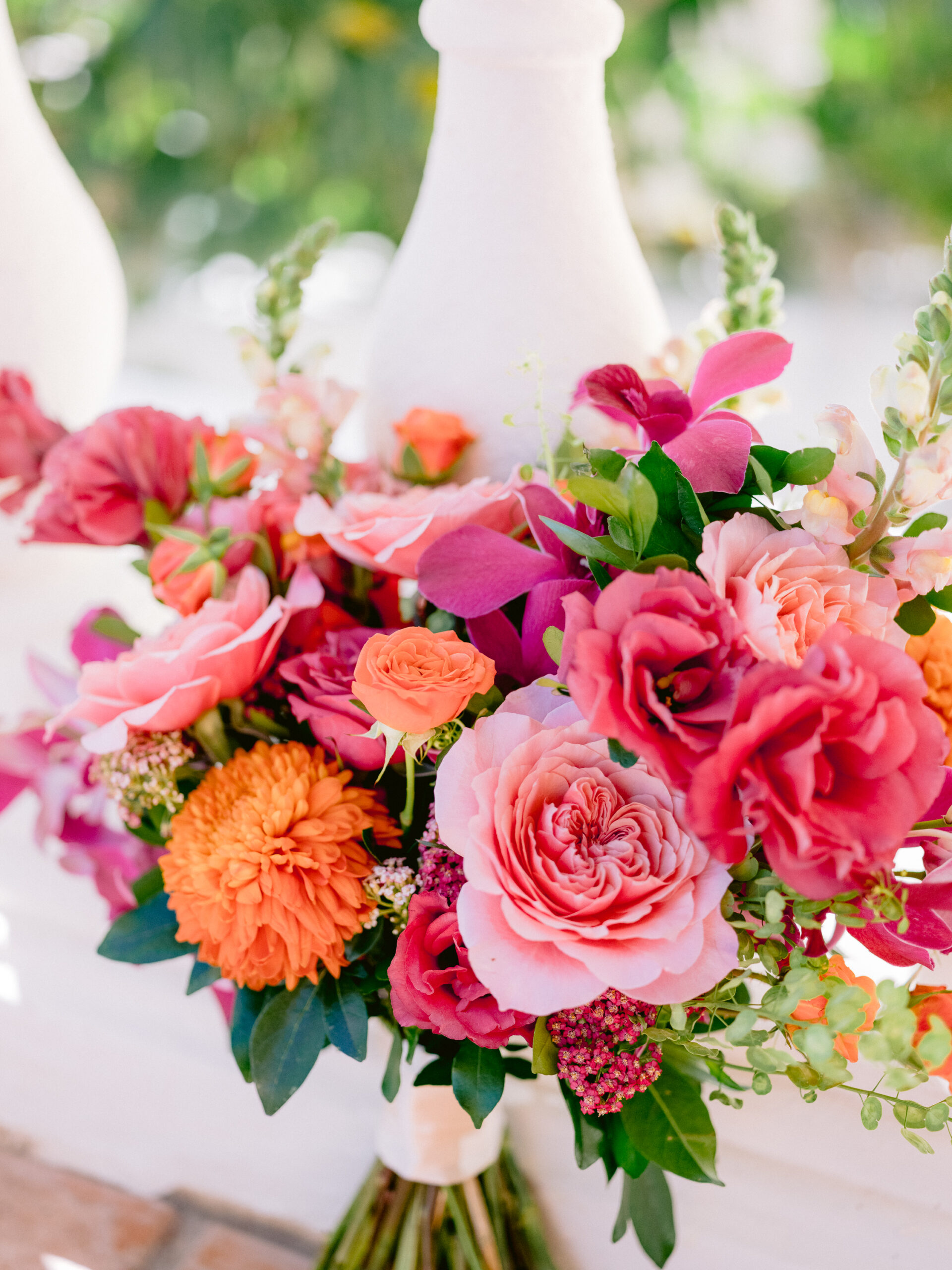 Vibrant pink, orange, and fuchsia floral arrangement in a tall white vase, perfect for a joyful Los Cabos flower delivery. Del Mar Floristería.